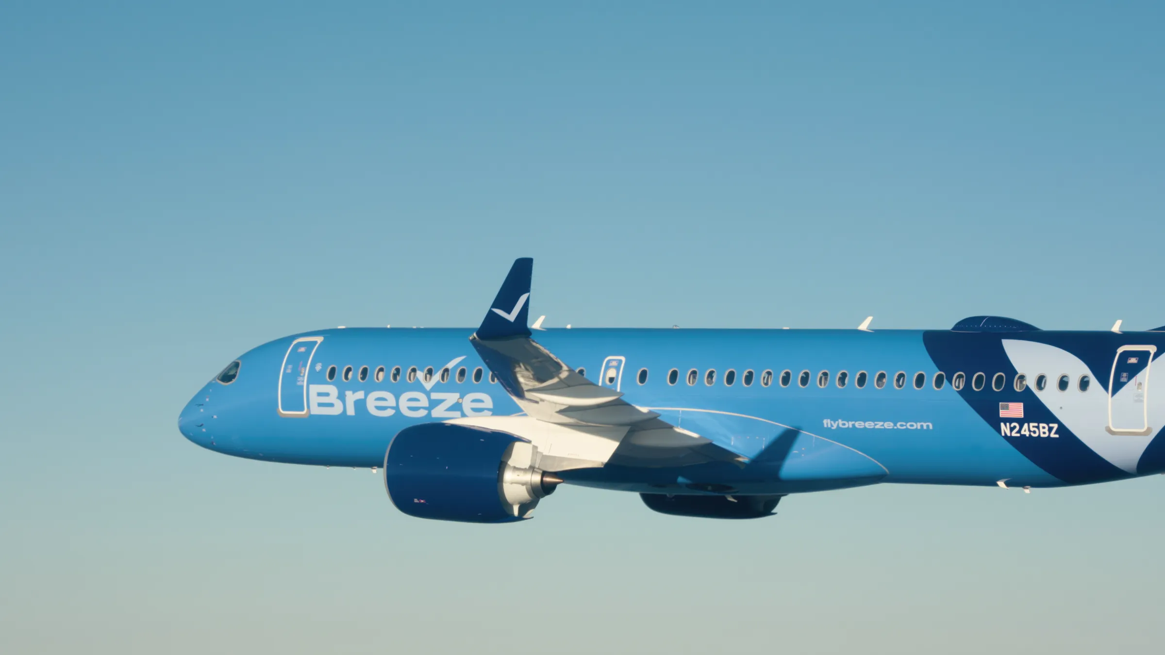 A Breeze Airways Airbus A220 in flight under a clear blue sky