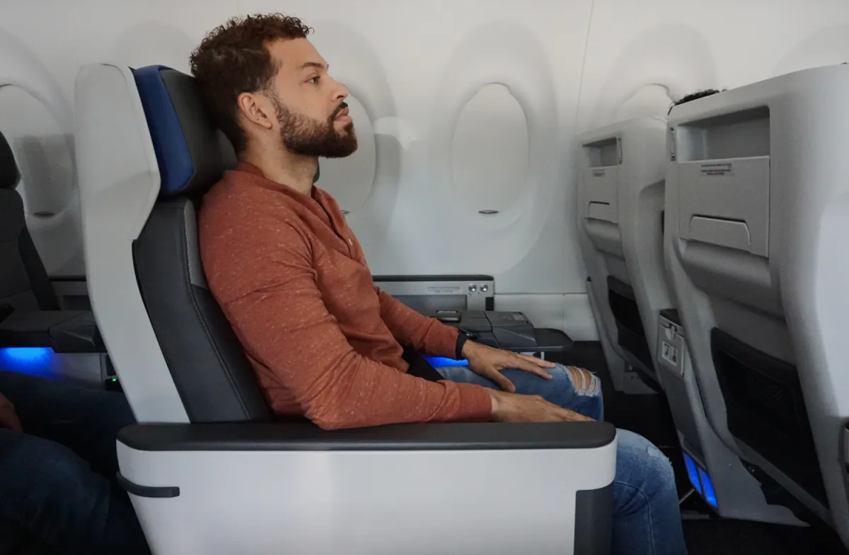 A traveler relaxing in a roomy leather seat by the window