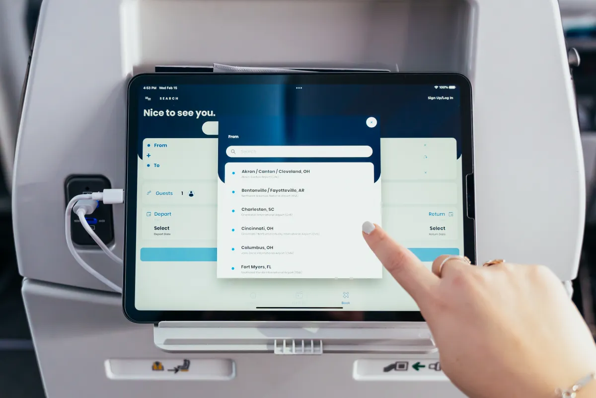 A traveler using a tablet in the seatback holder