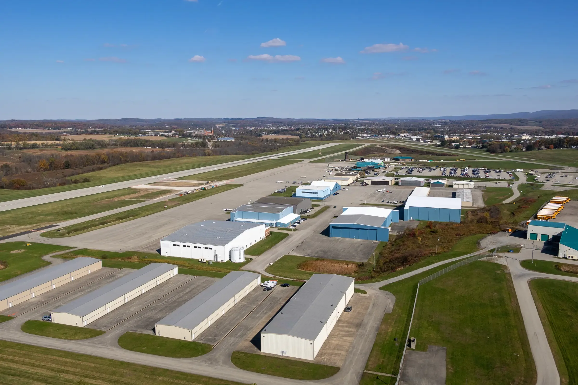 Hangars and the runway at Arnold Palmer Regional Airport from the air, with the Laurel Highlands beyond