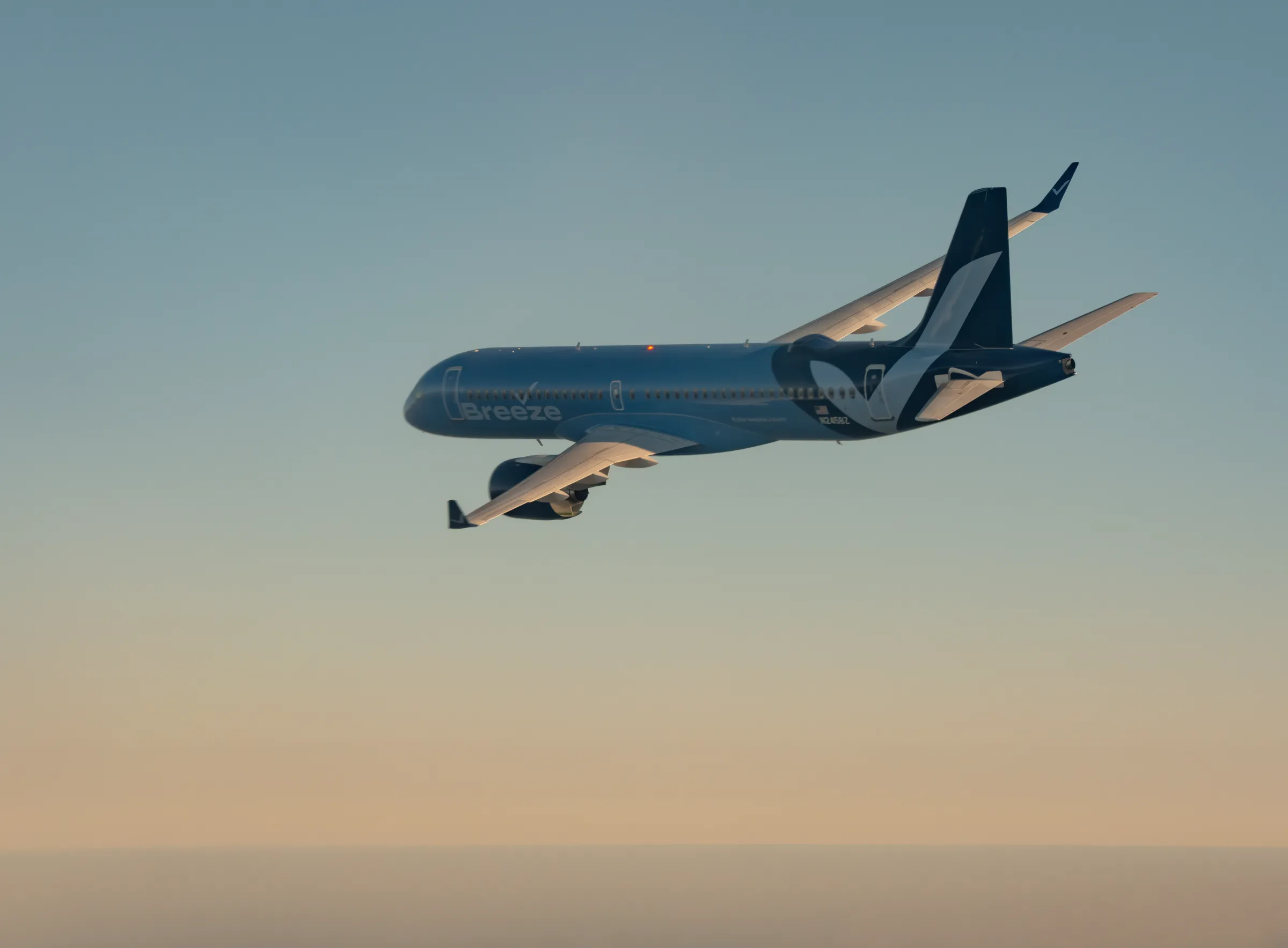 A Breeze Airways Airbus A220 in flight against an evening sky