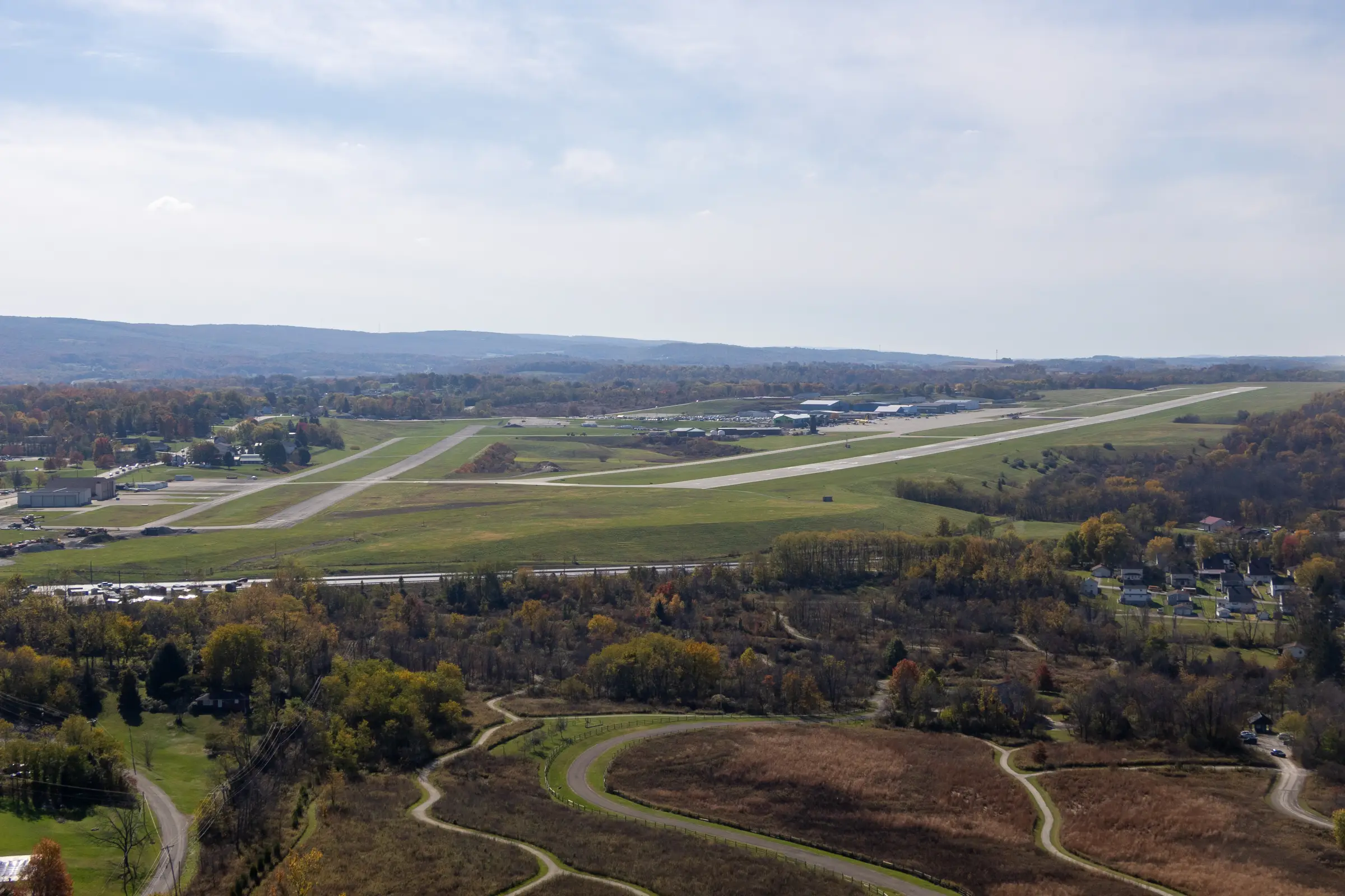 The runway at Arnold Palmer Regional Airport from the air, with the ridges of the Laurel Highlands behind it